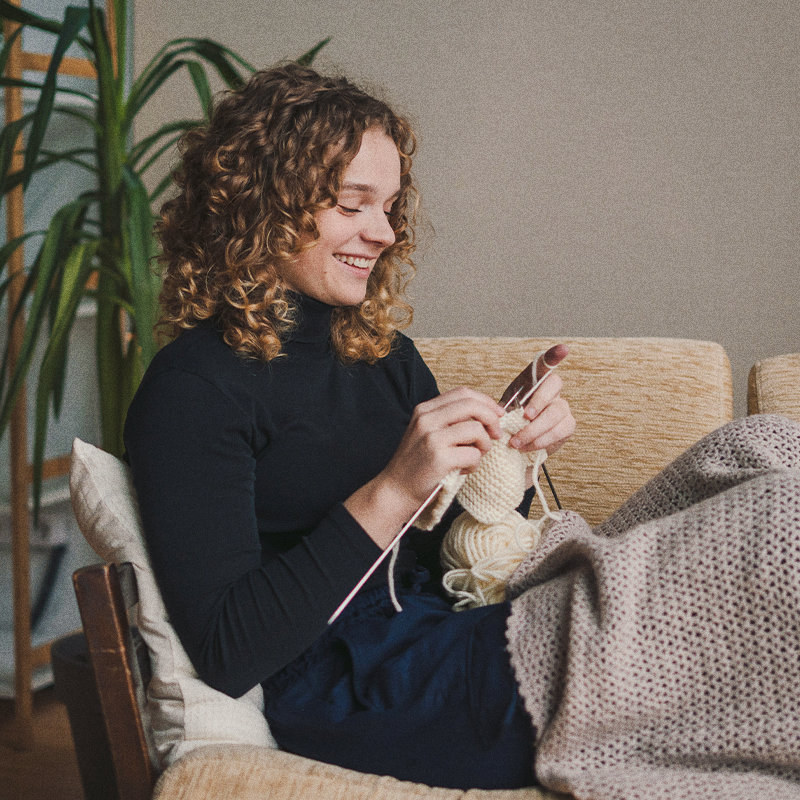 Strick-Held in mit Strickzeug in der Hand