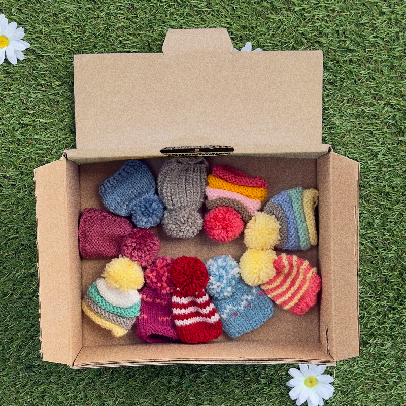 Schachtel mit gestrickten Mützen